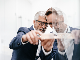 Male employee explaining graph on transparent board