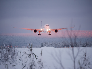 Aircraft flying over snowy landscape