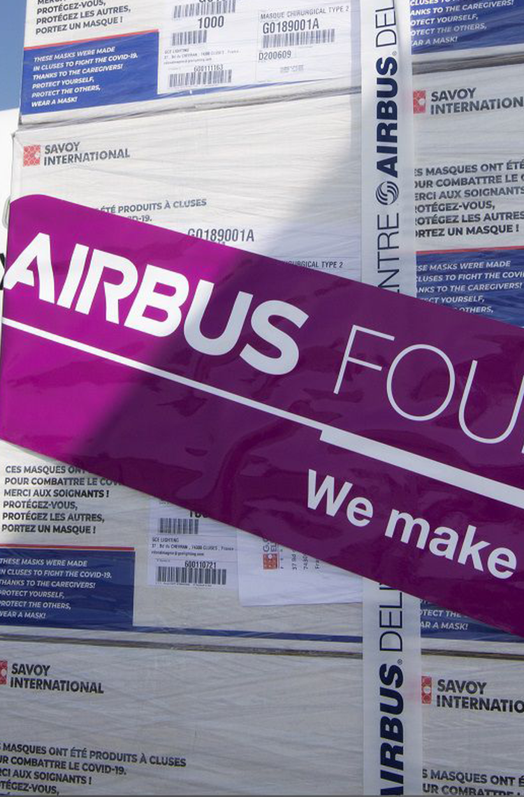 Packages with Airbus Foundation sticker in front of an airplane