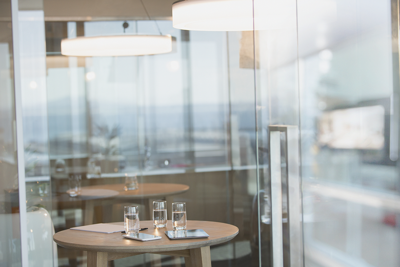 Water glasses and digital tablets on table in conference room