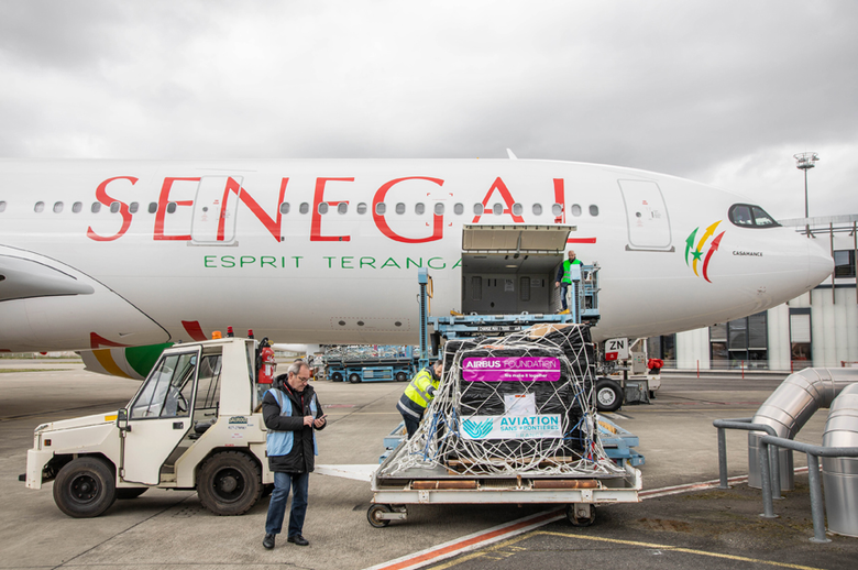 Loading relief supplies from the Airbus Foundation onto an Air Senegal aircraft.